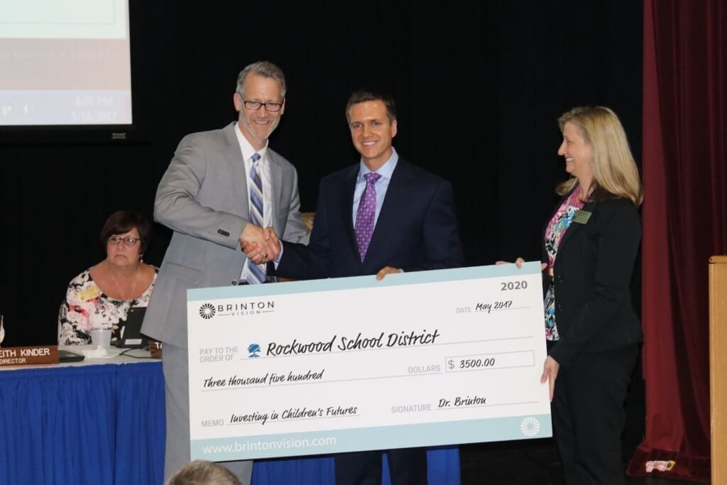 Dr. Jason P. Brinton presents a check to Rockwood School District to purchase solar eclipse viewing glasses for every student in the district.