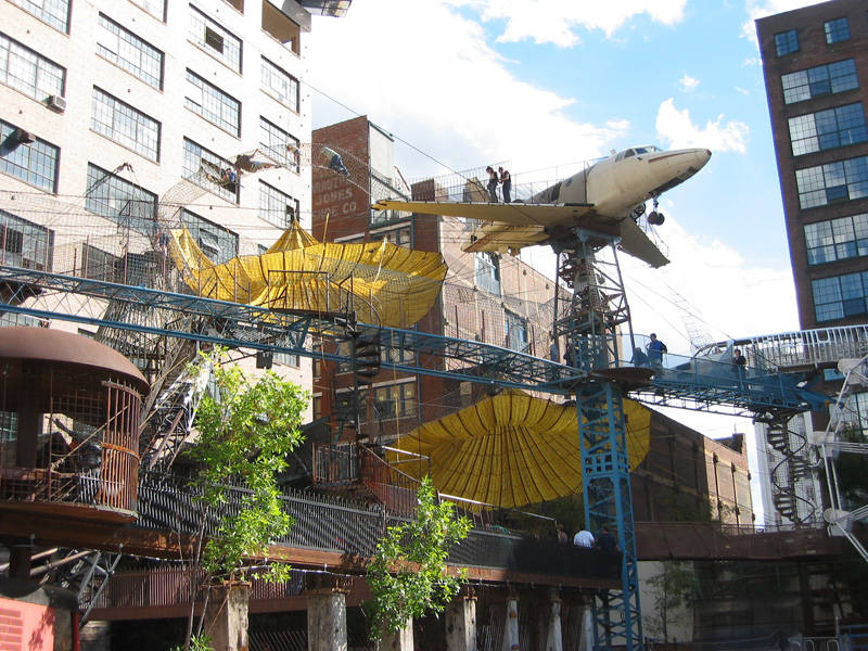 City Museum, external view of metal tracks and pathways, as well as a plane that a couple is walking away from