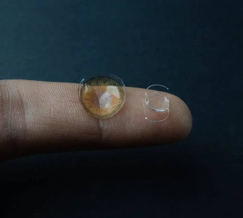 contact lens and intraocular lens implant on a fingertip